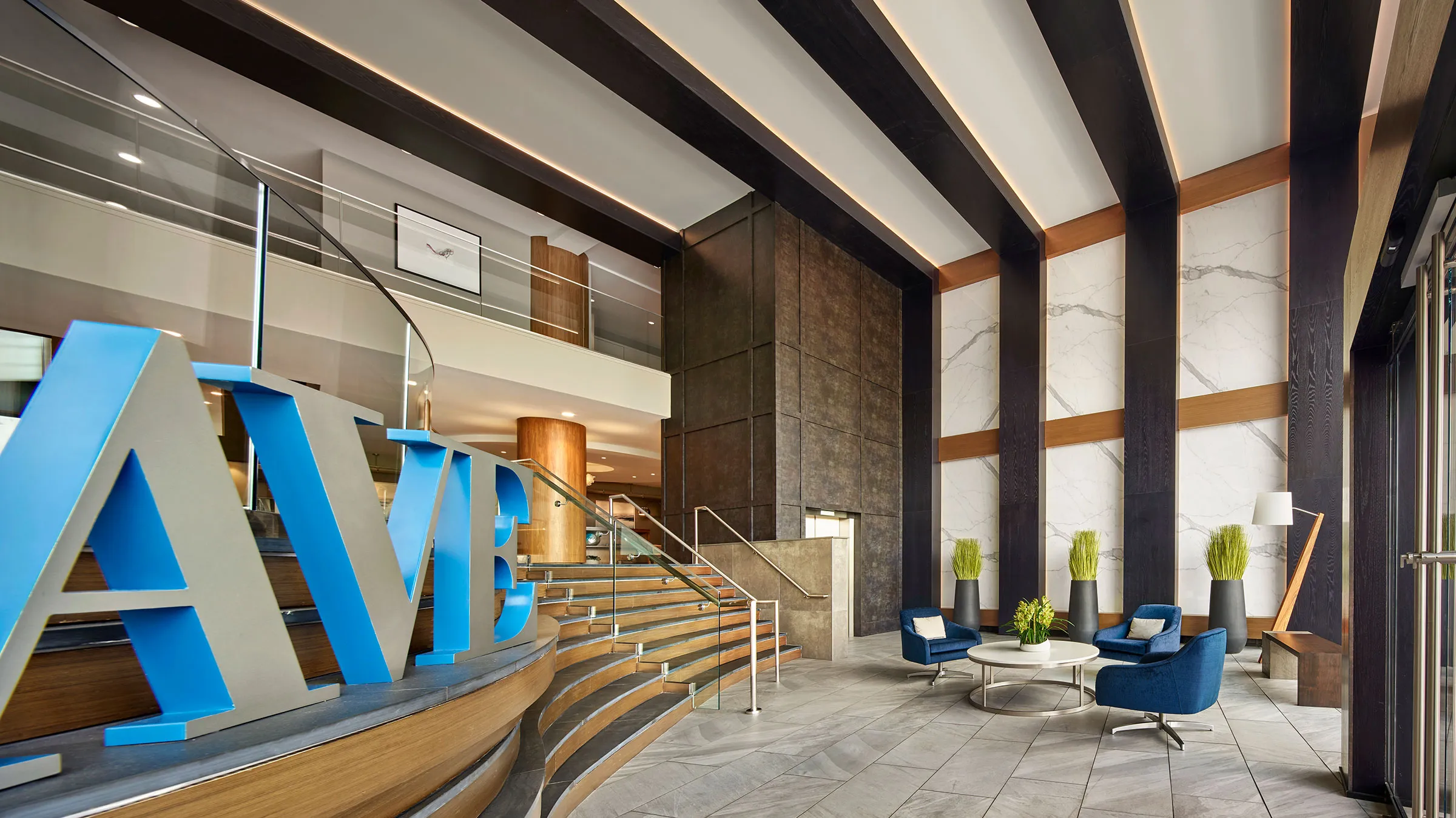 a lobby with stairs and a large blue sign