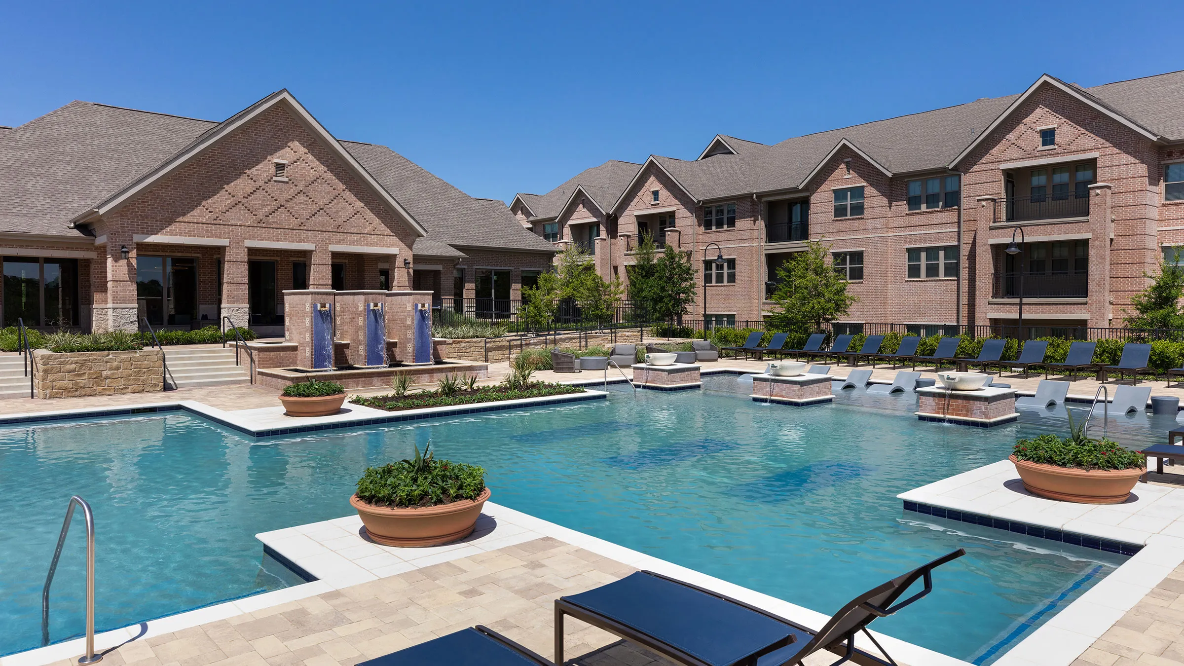 a pool with chairs and a building in the background