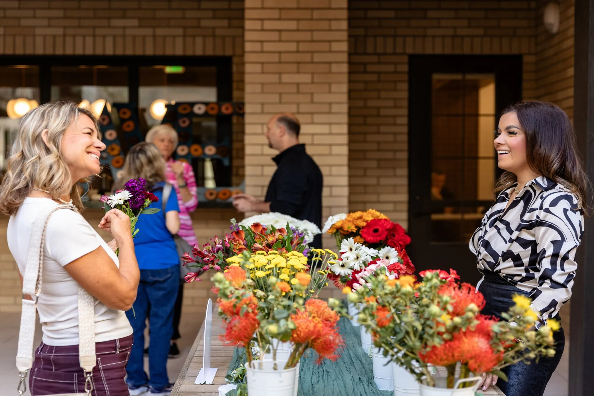 Women smiling at a bouquet-making event