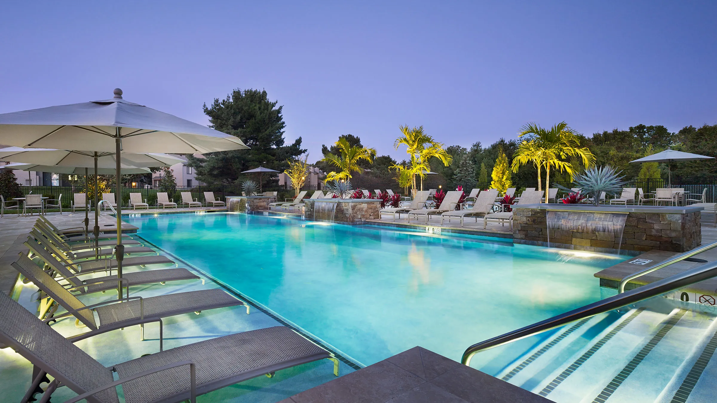 a pool with lounge chairs and a waterfall