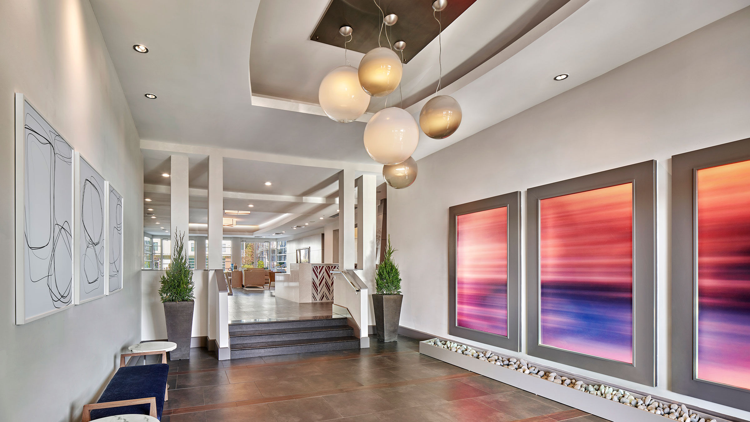 a hallway with a staircase and art