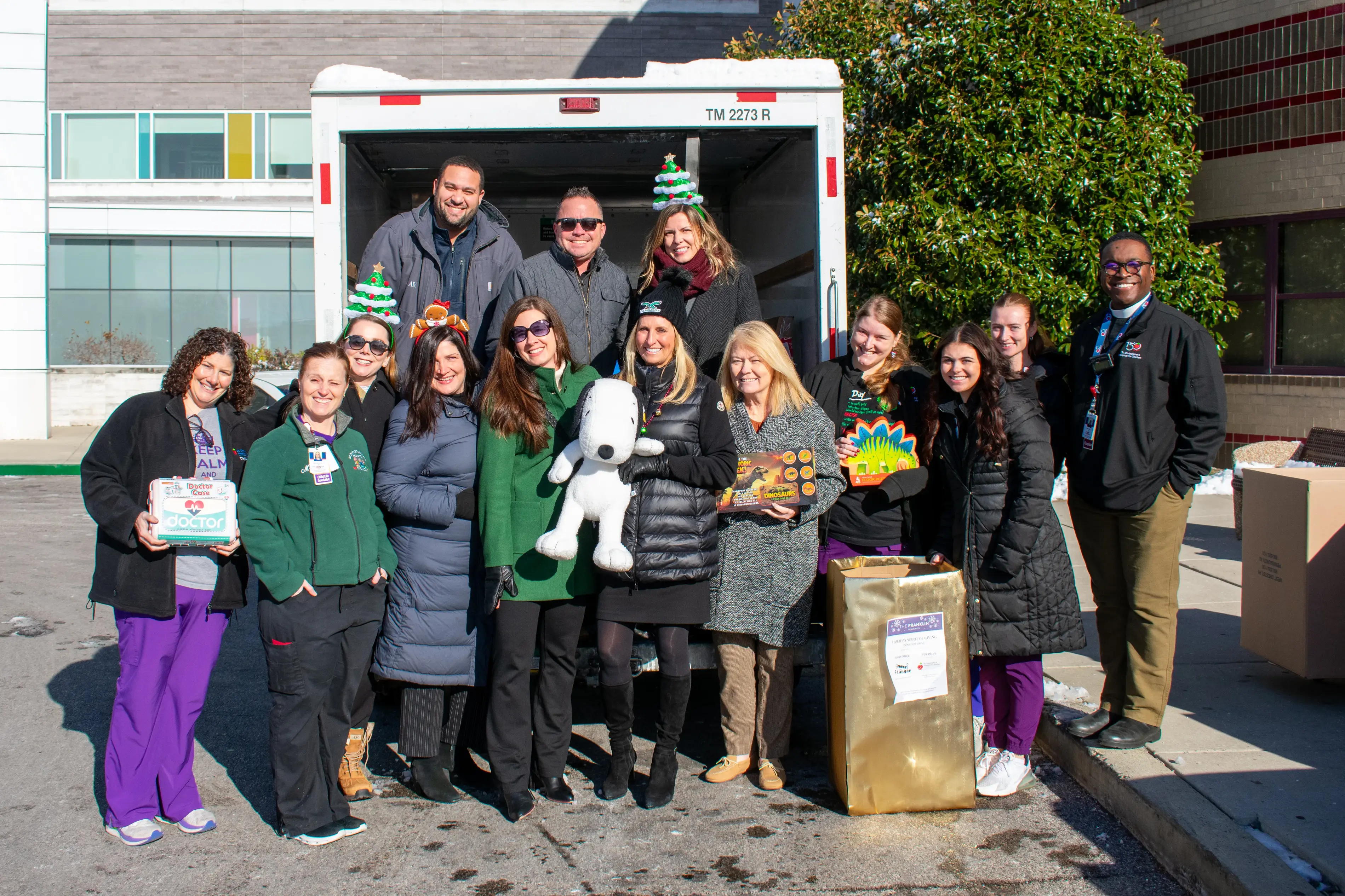 a group of people posing for a photo in front of a truck