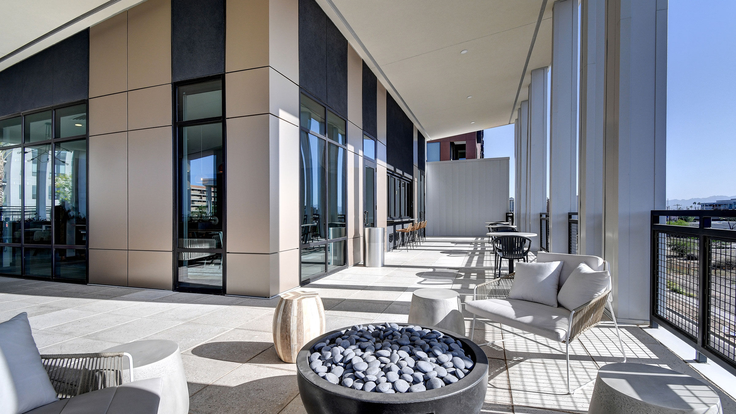 a patio with chairs and a fire pit