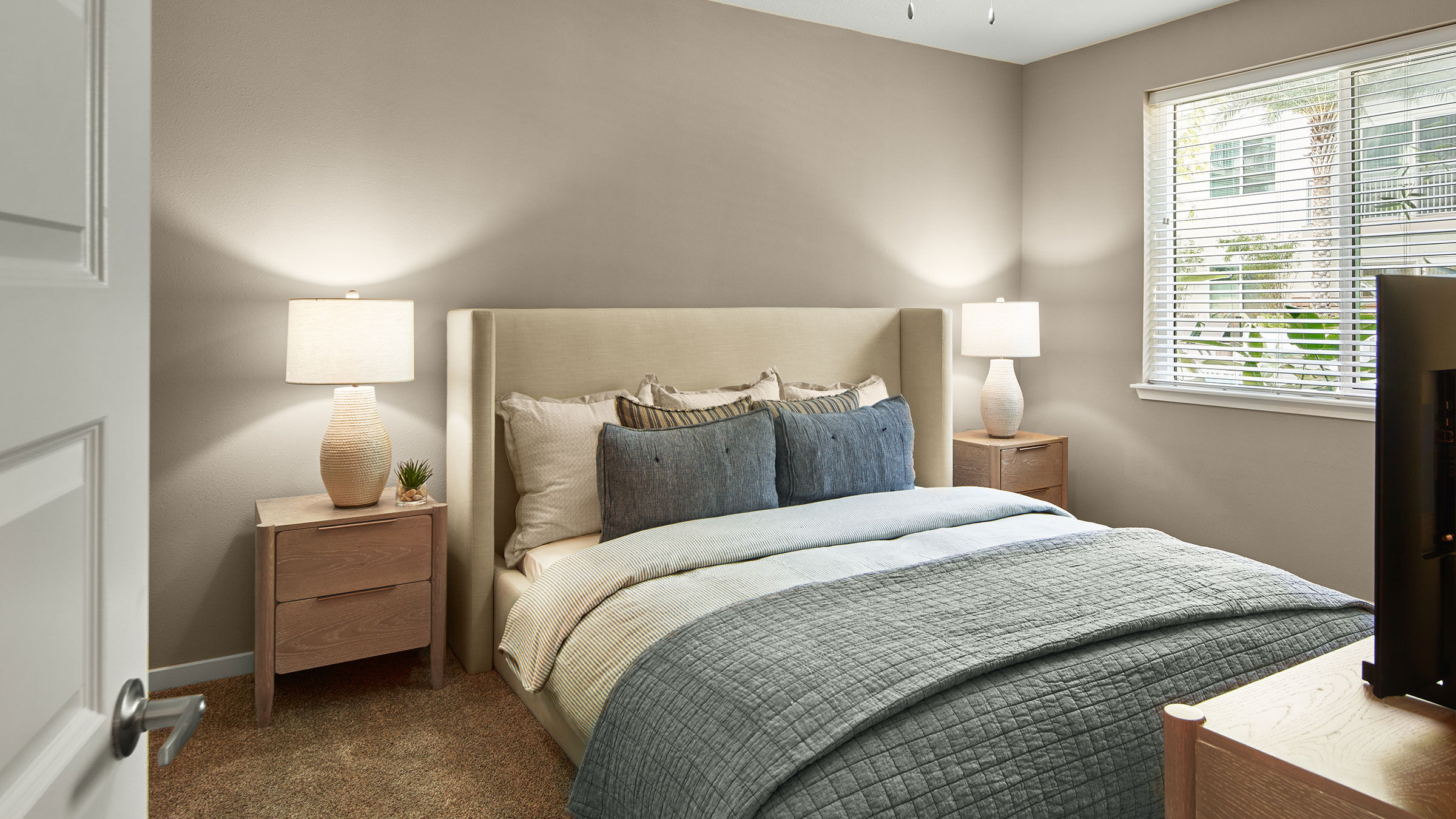 a bed with a headboard and two lamps