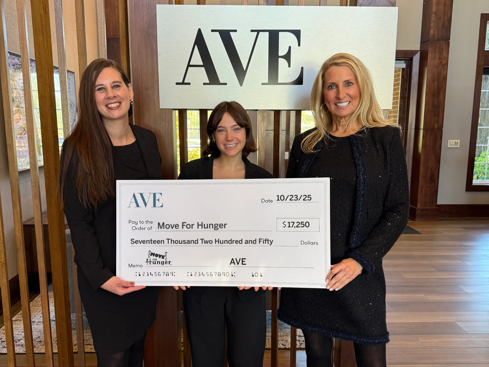 Three women smiling holding a check for Move For Hunger