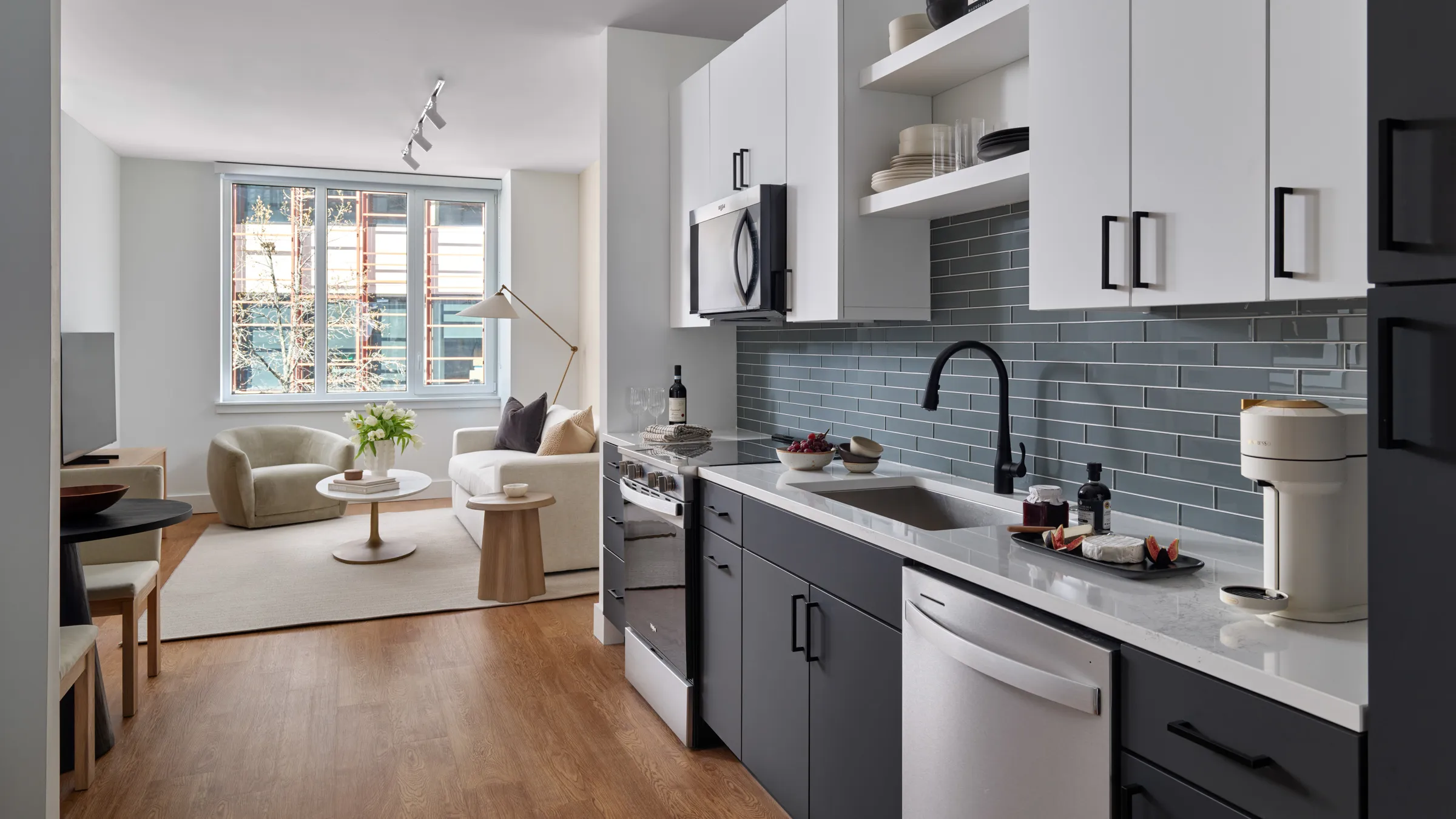 a kitchen with white cabinets and black appliances