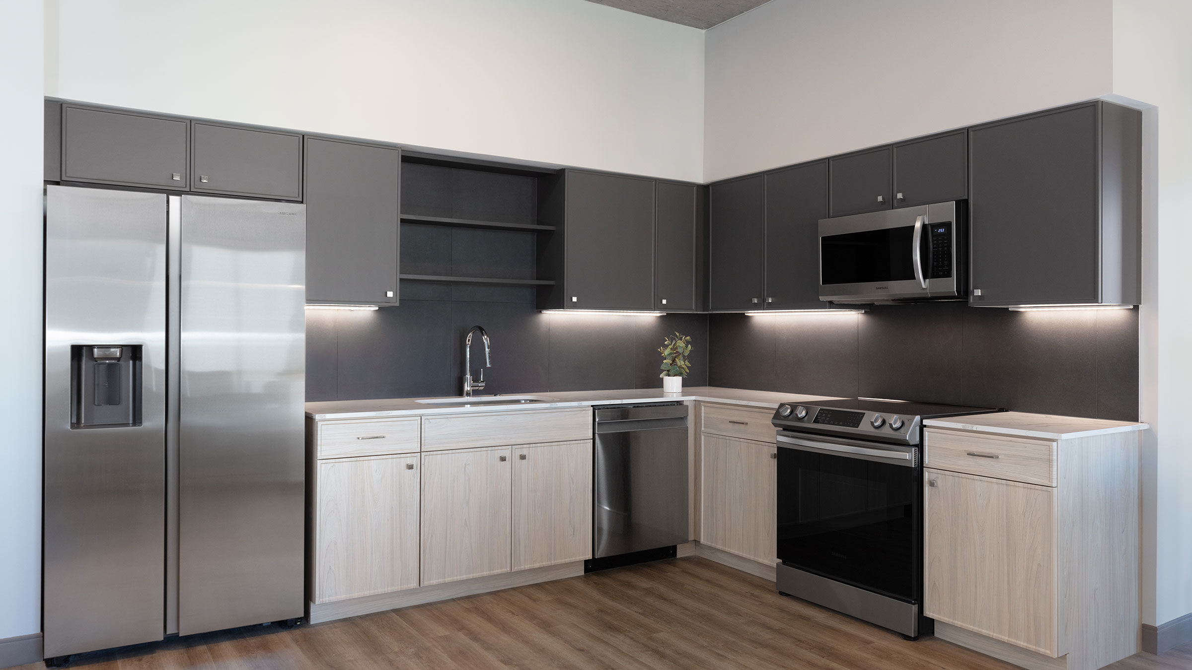a kitchen with grey cabinets and stainless steel appliances