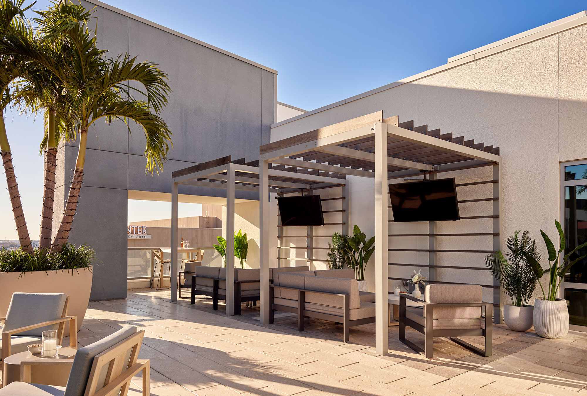 a patio with a pergola and a palm tree