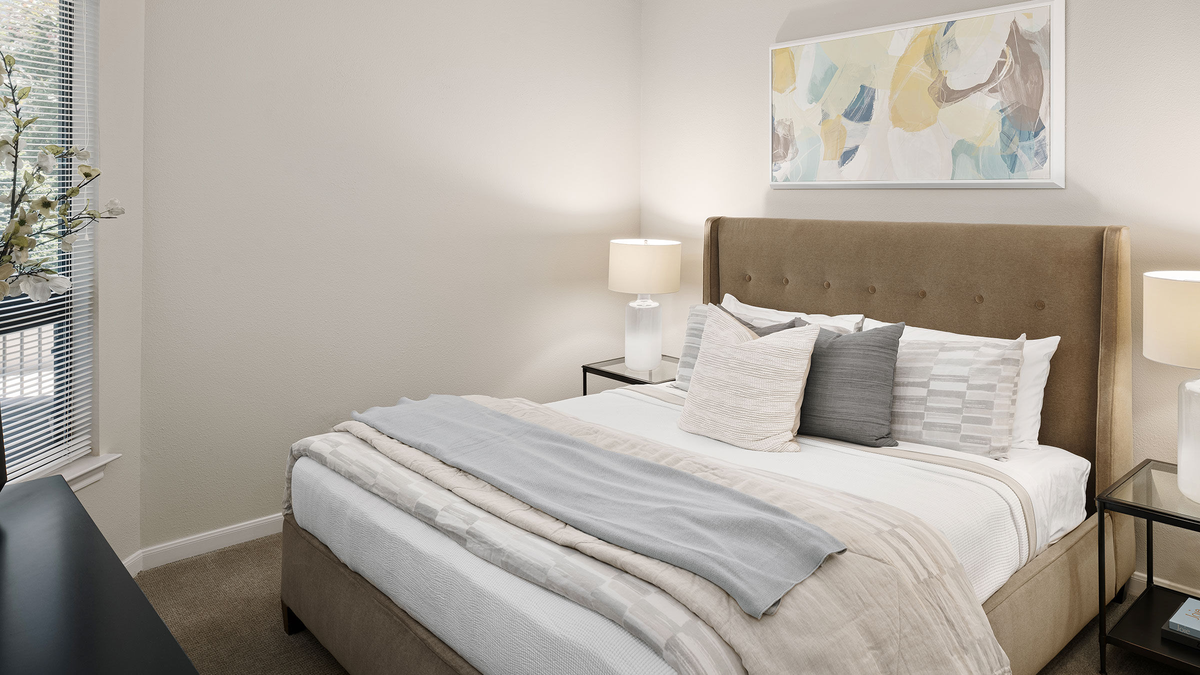 a bed with pillows and a lamp on the side