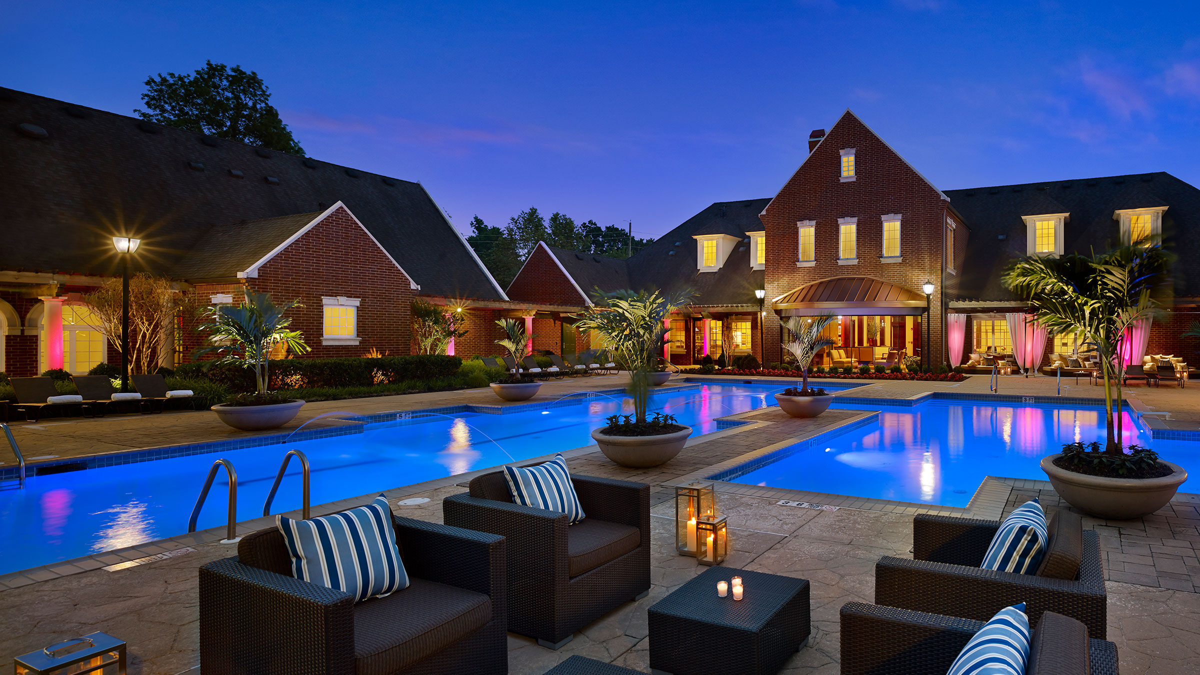a pool with chairs and a building in the background