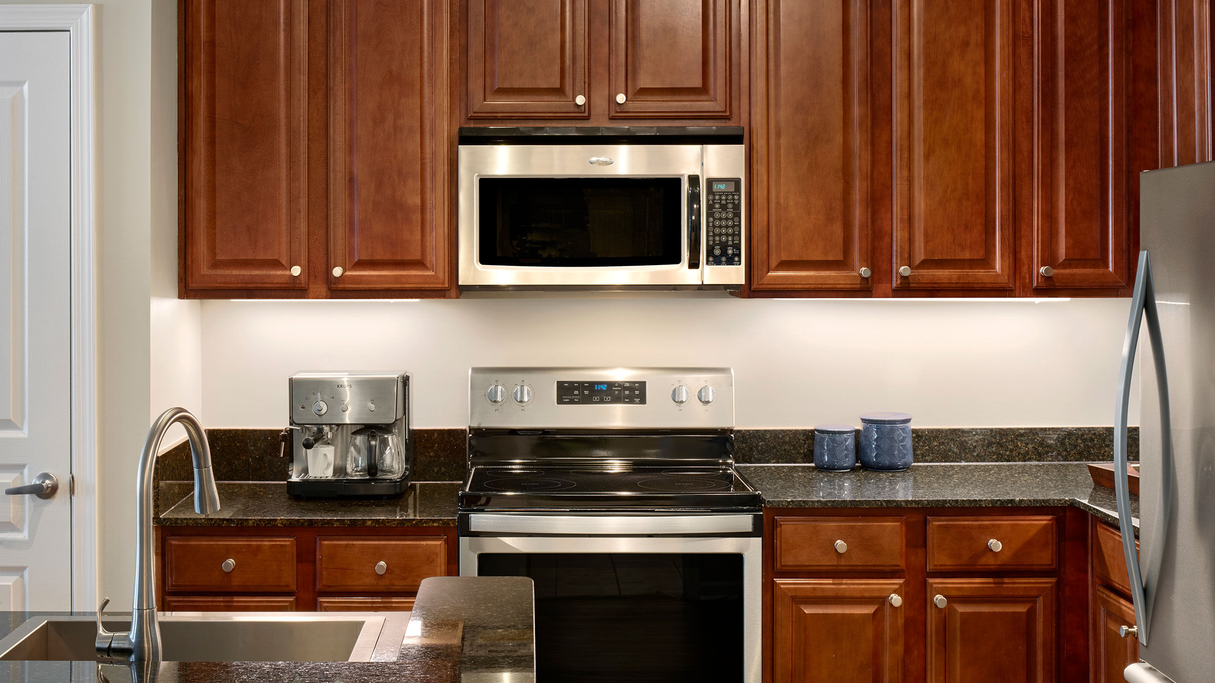 a kitchen with a stainless steel stove and microwave