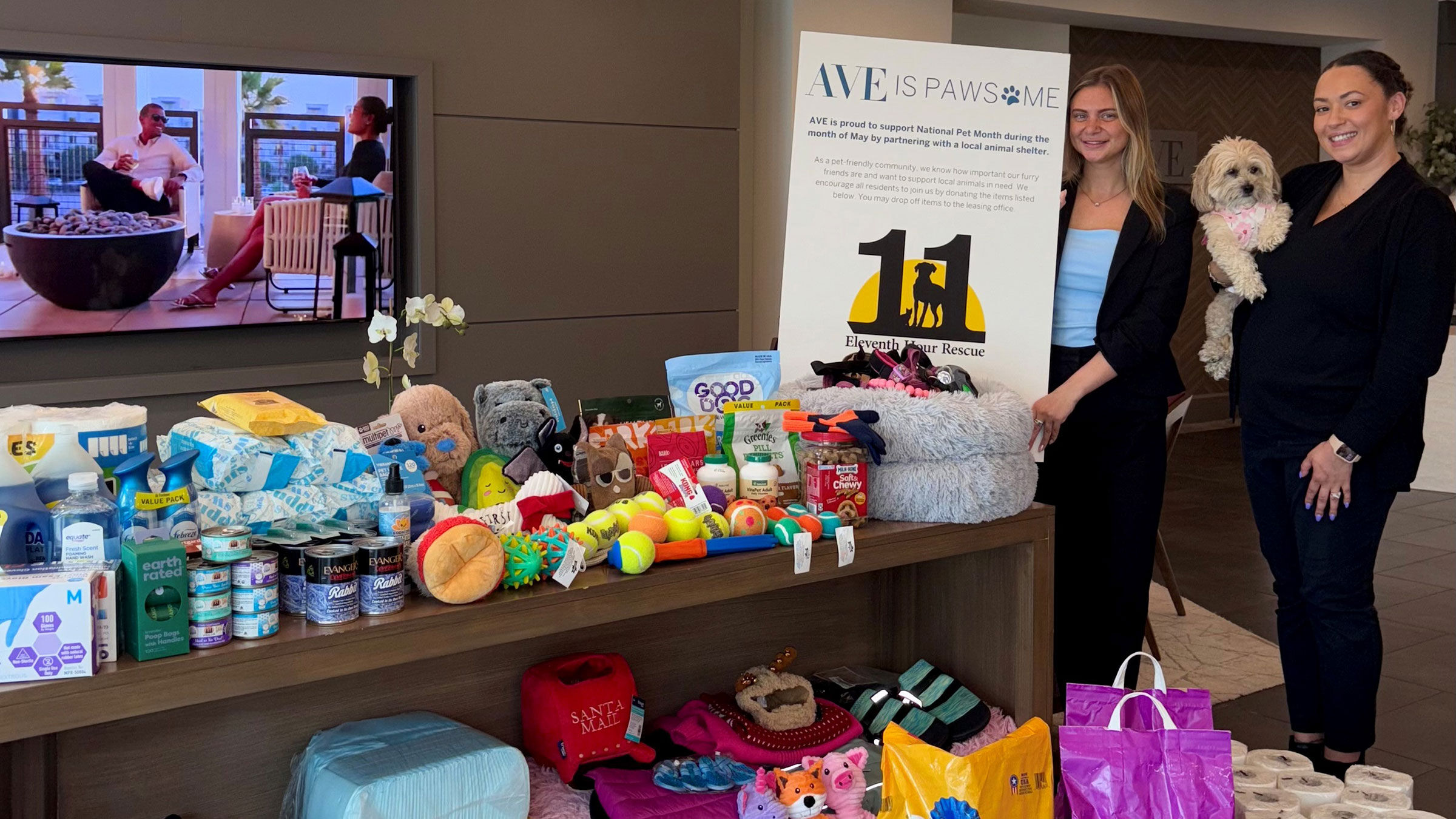 a woman standing next to a table full of donated pet supplies