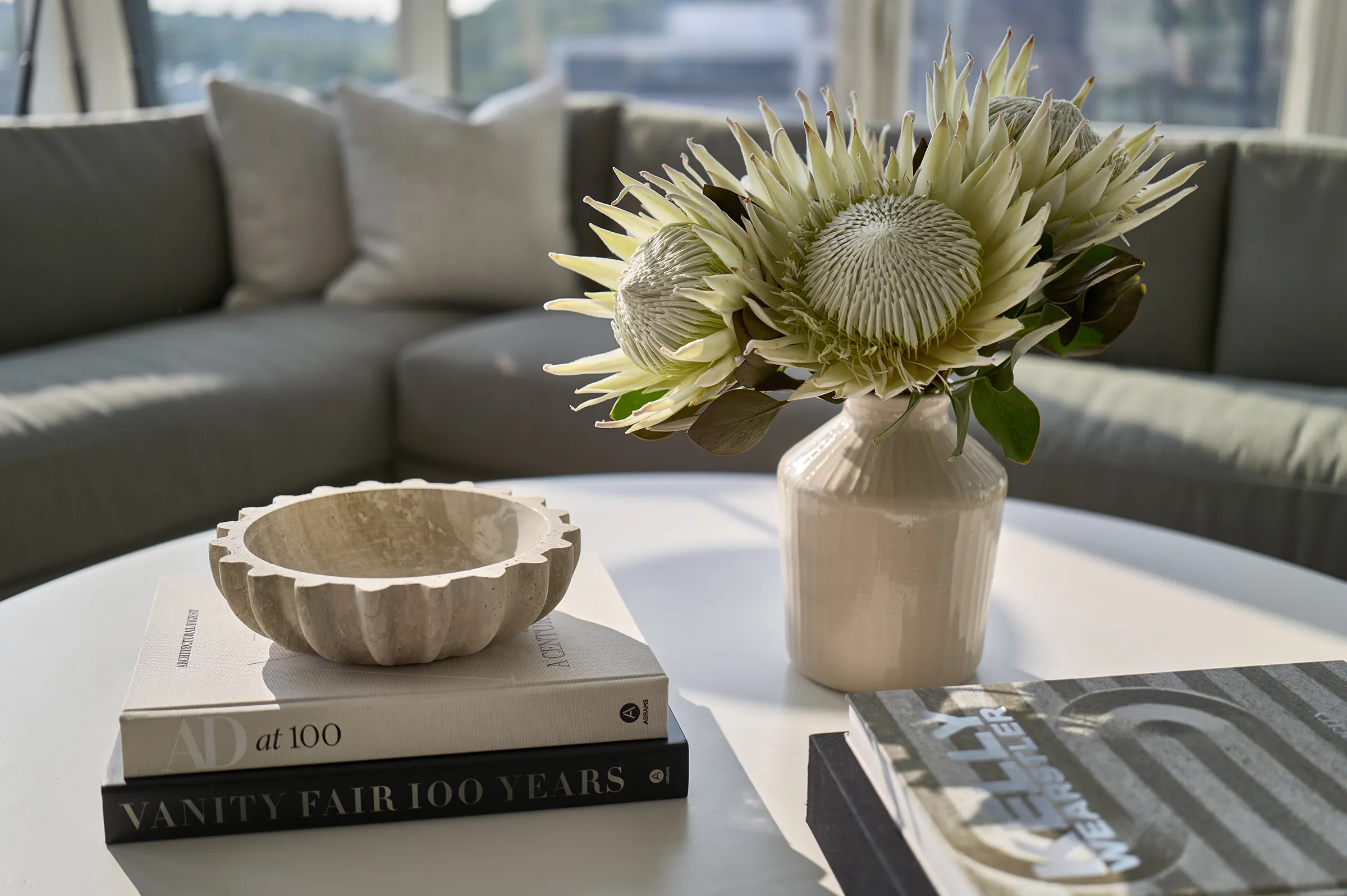 a vase with flowers and a bowl on a table