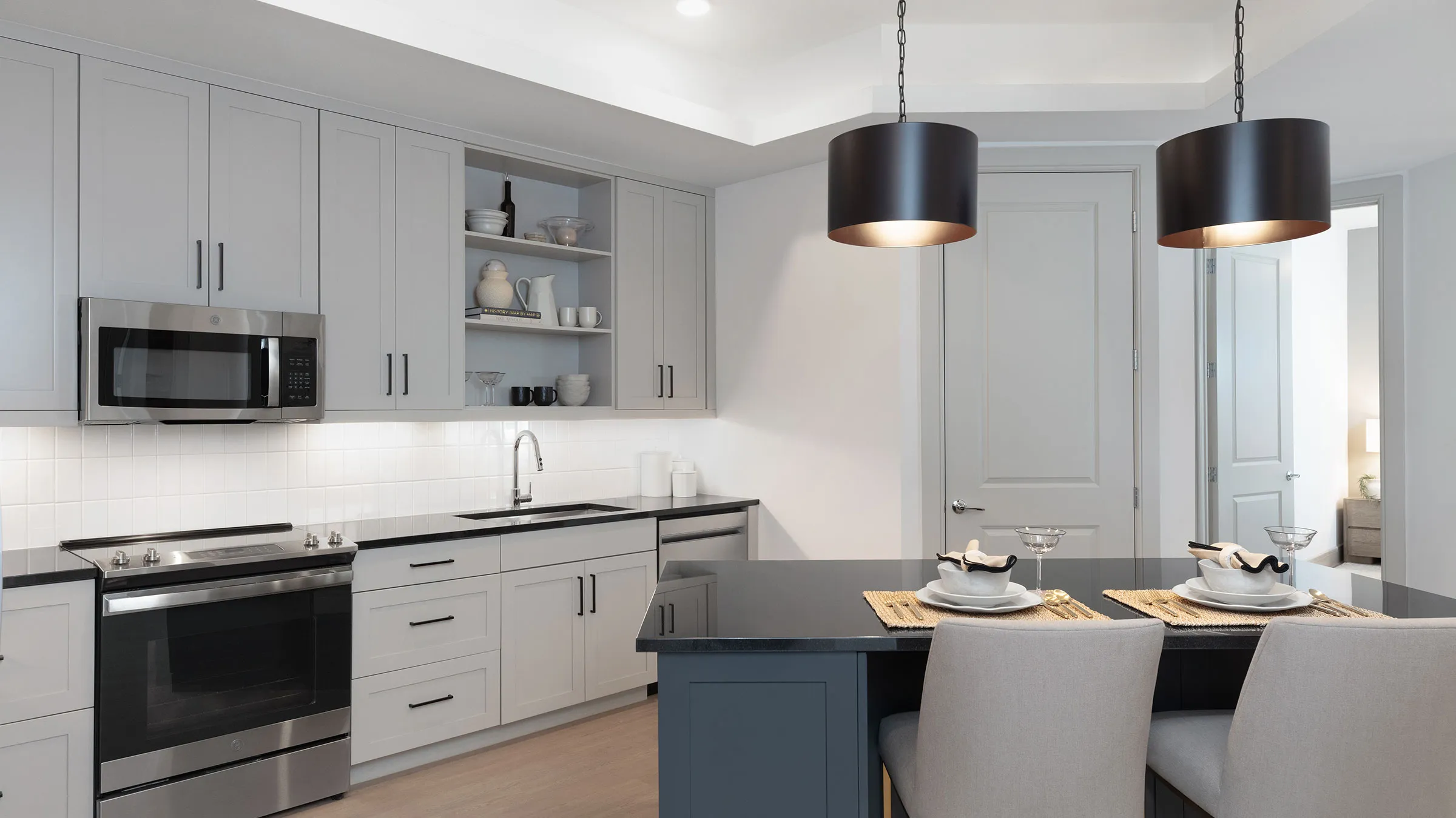 a kitchen with a black countertop and a black pendant light