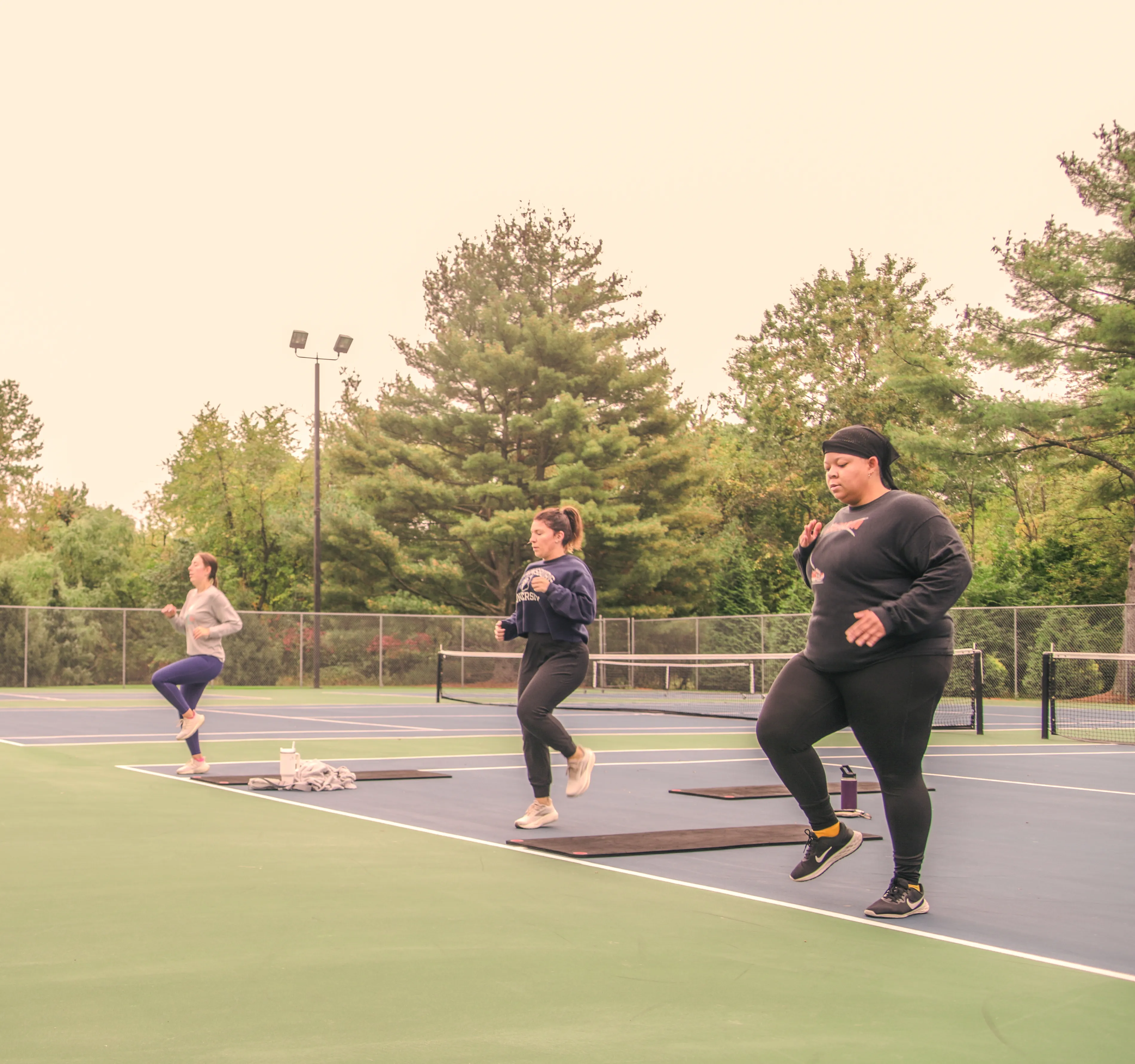 a group of women running on a tennis court