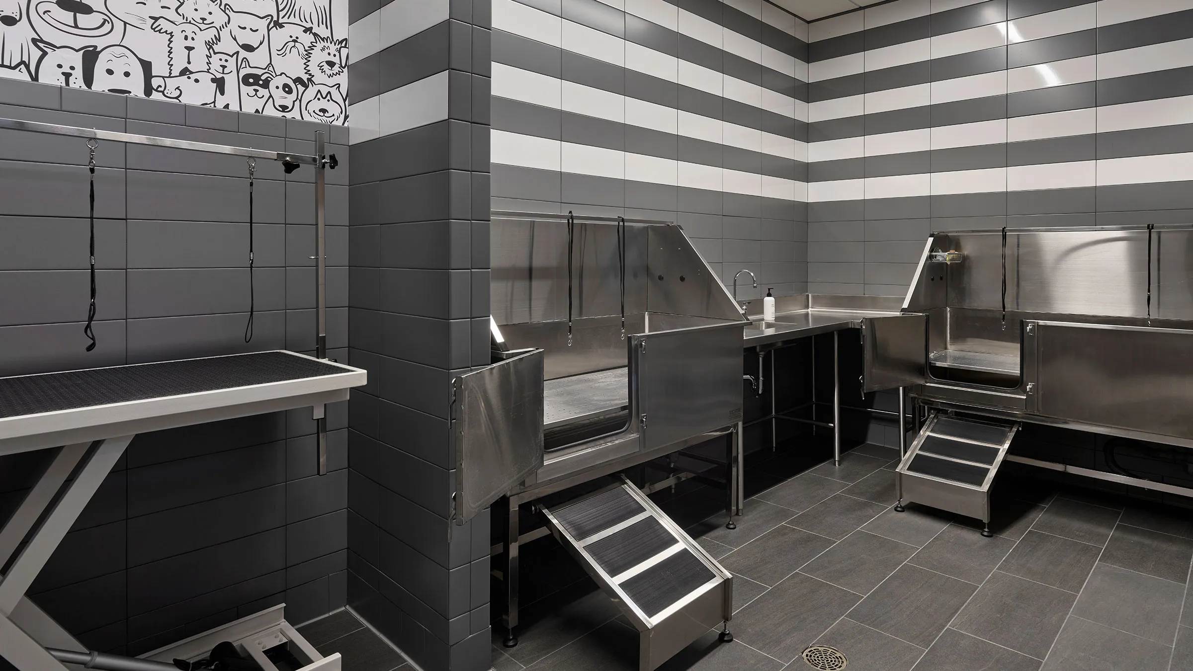 a grey and white striped wall with stainless steel sinks