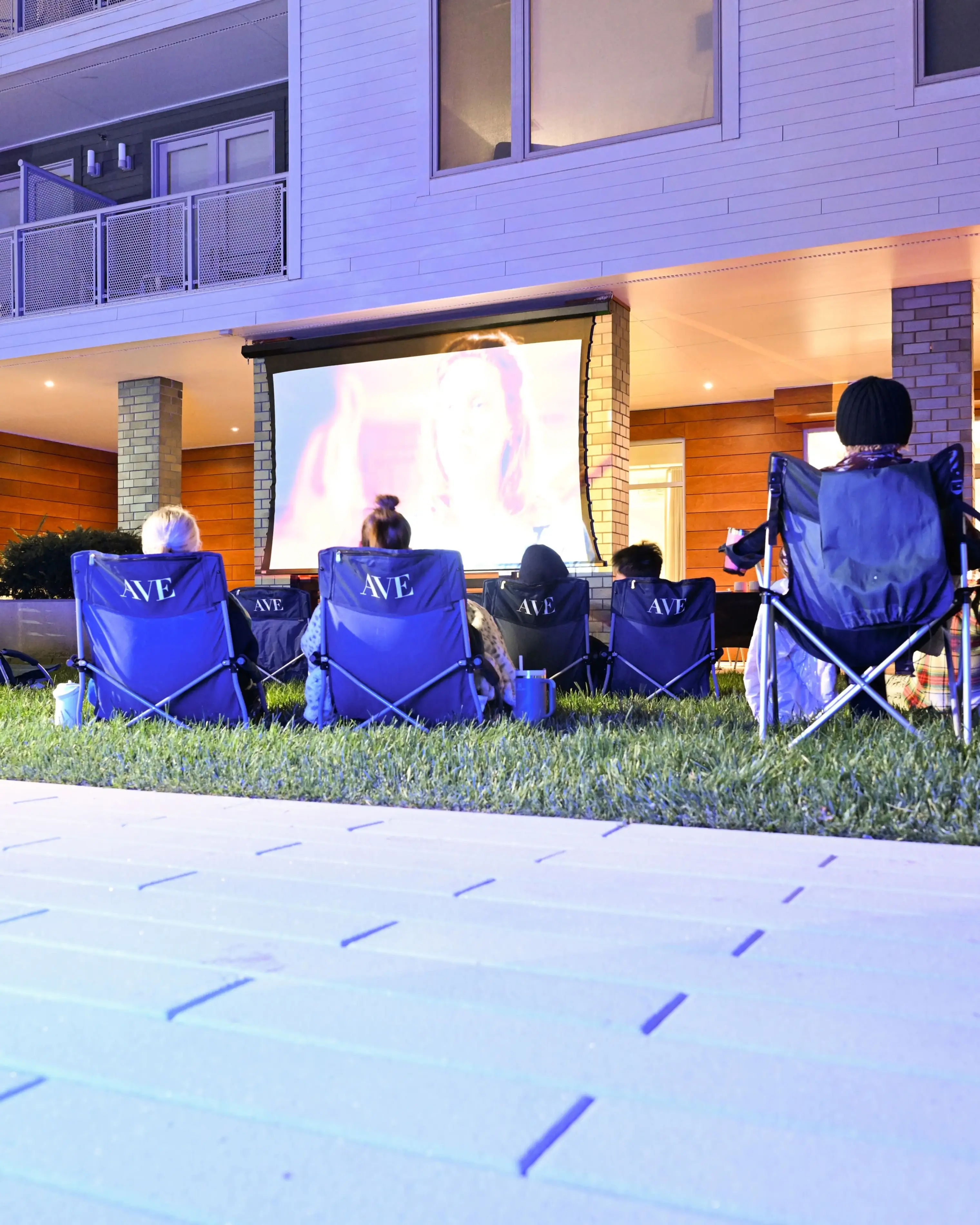 a group of people sitting in chairs in front of a house