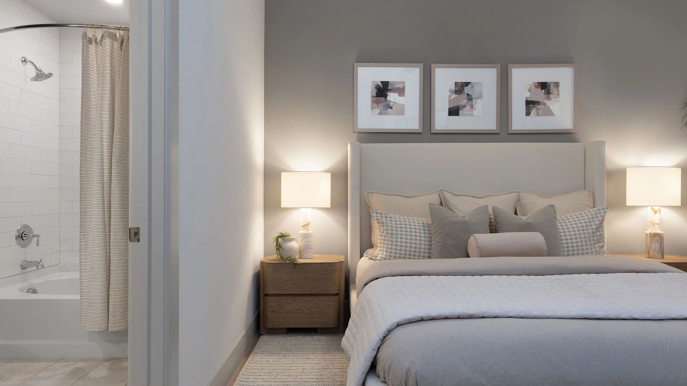 a bed with a lamp and pictures on the wall