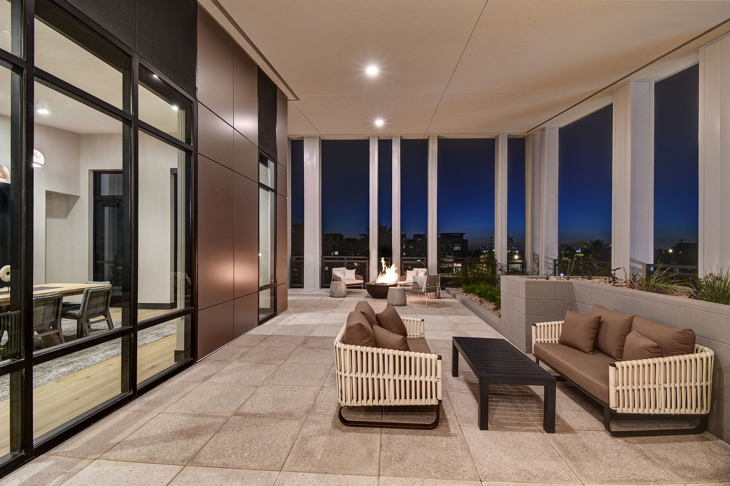 a patio with a fire pit and chairs