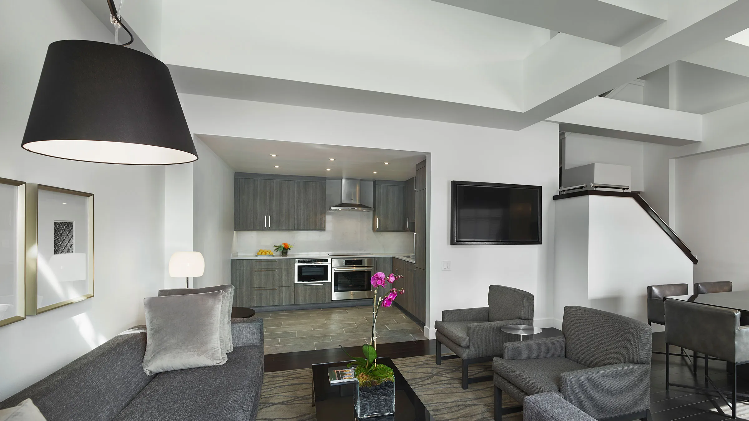 a living room with grey furniture and a tv