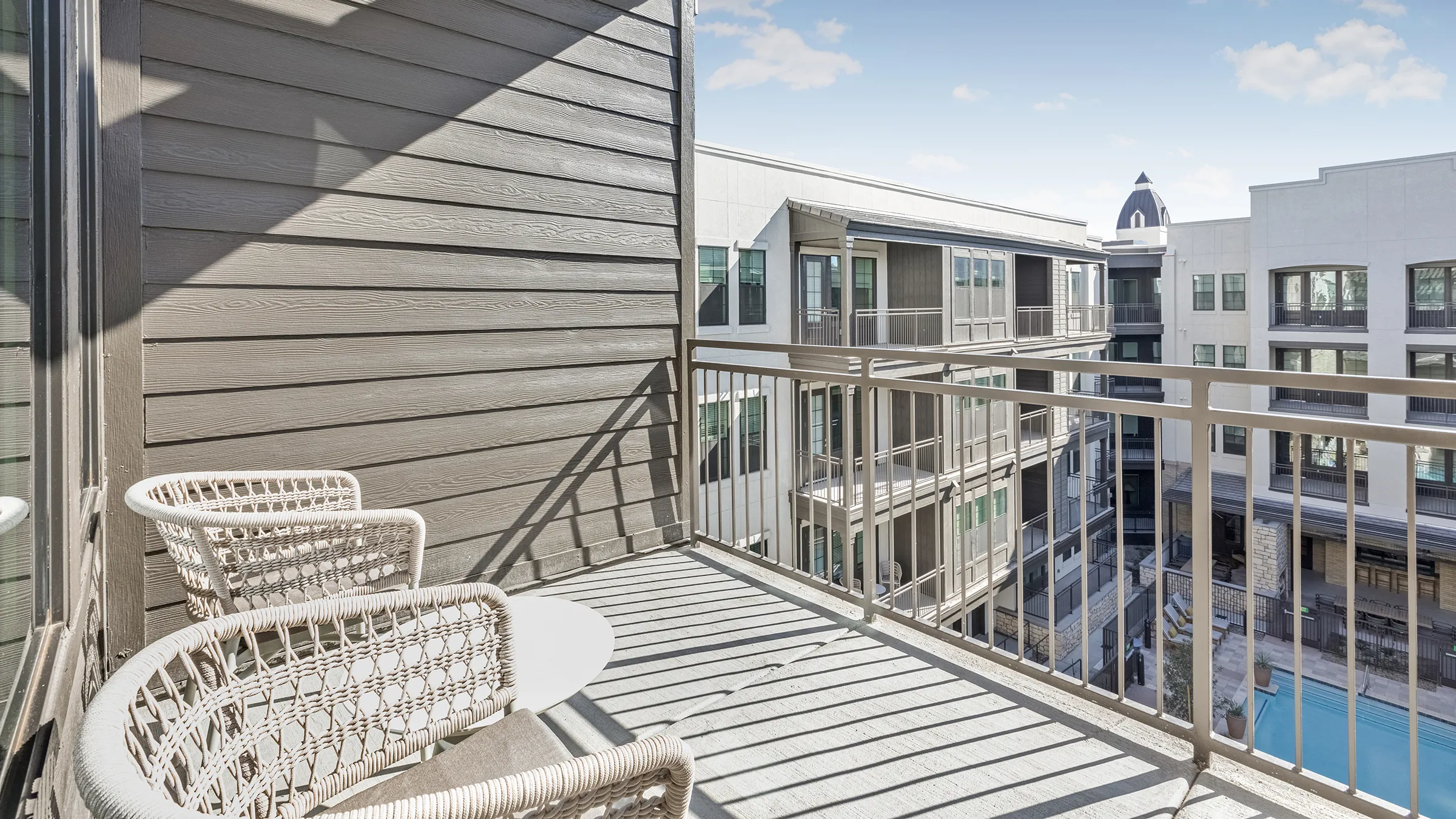 a balcony with chairs and a railing