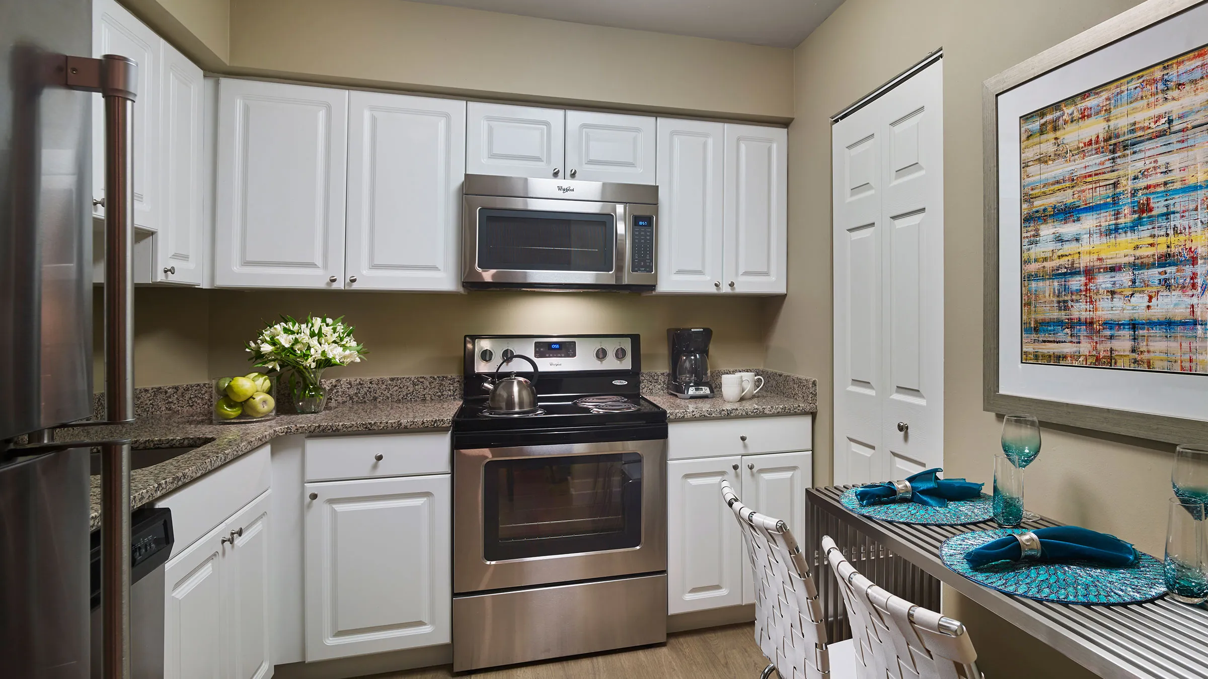 a kitchen with white cabinets and a stainless steel stove