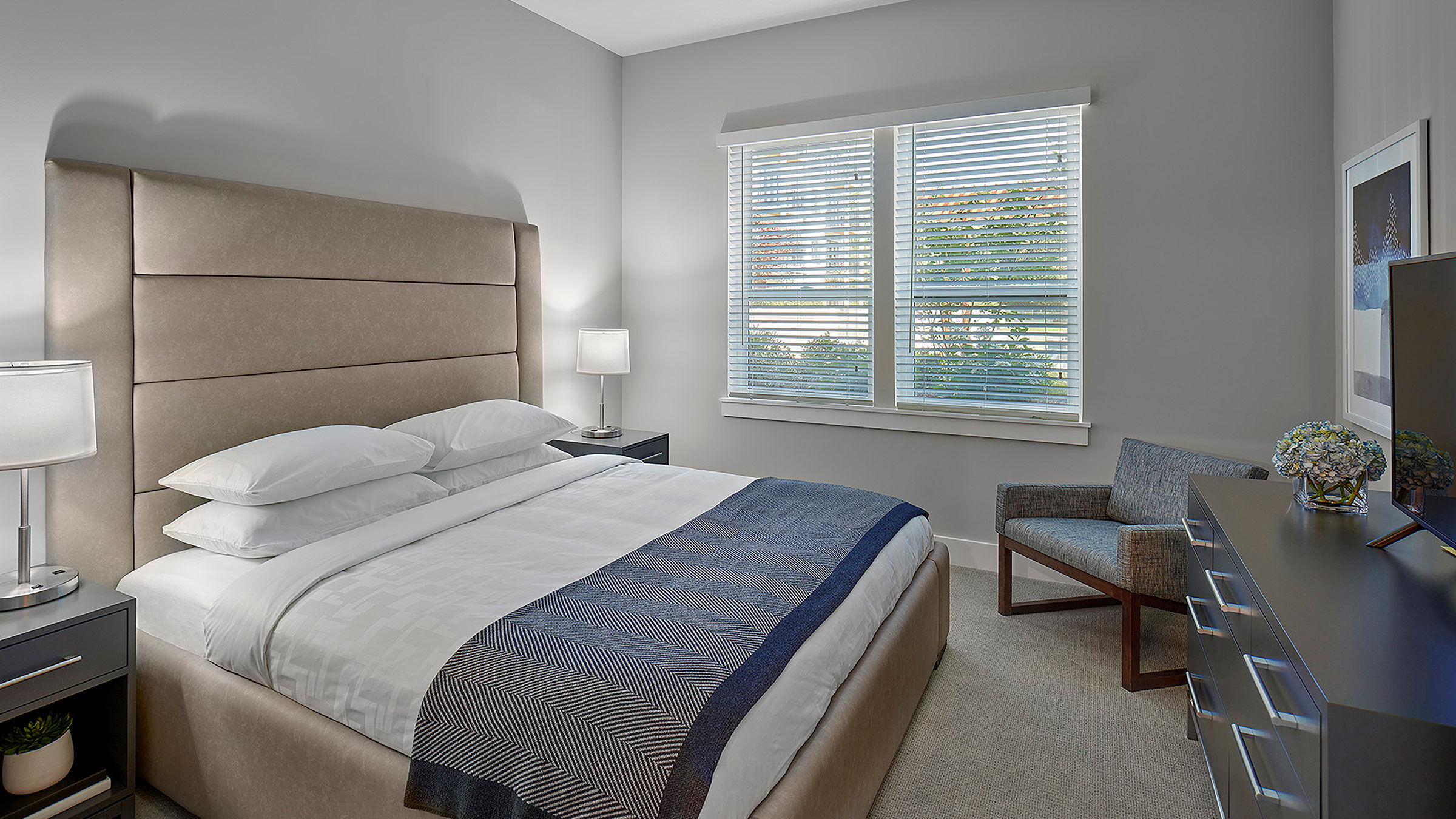 a bedroom with a bed and a chair