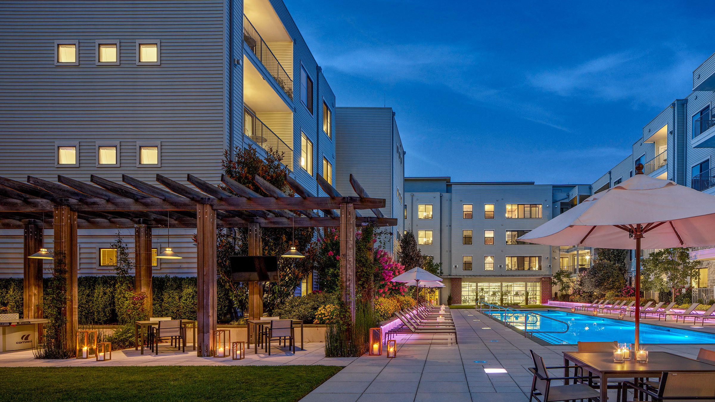 a pool and patio area with chairs and umbrellas