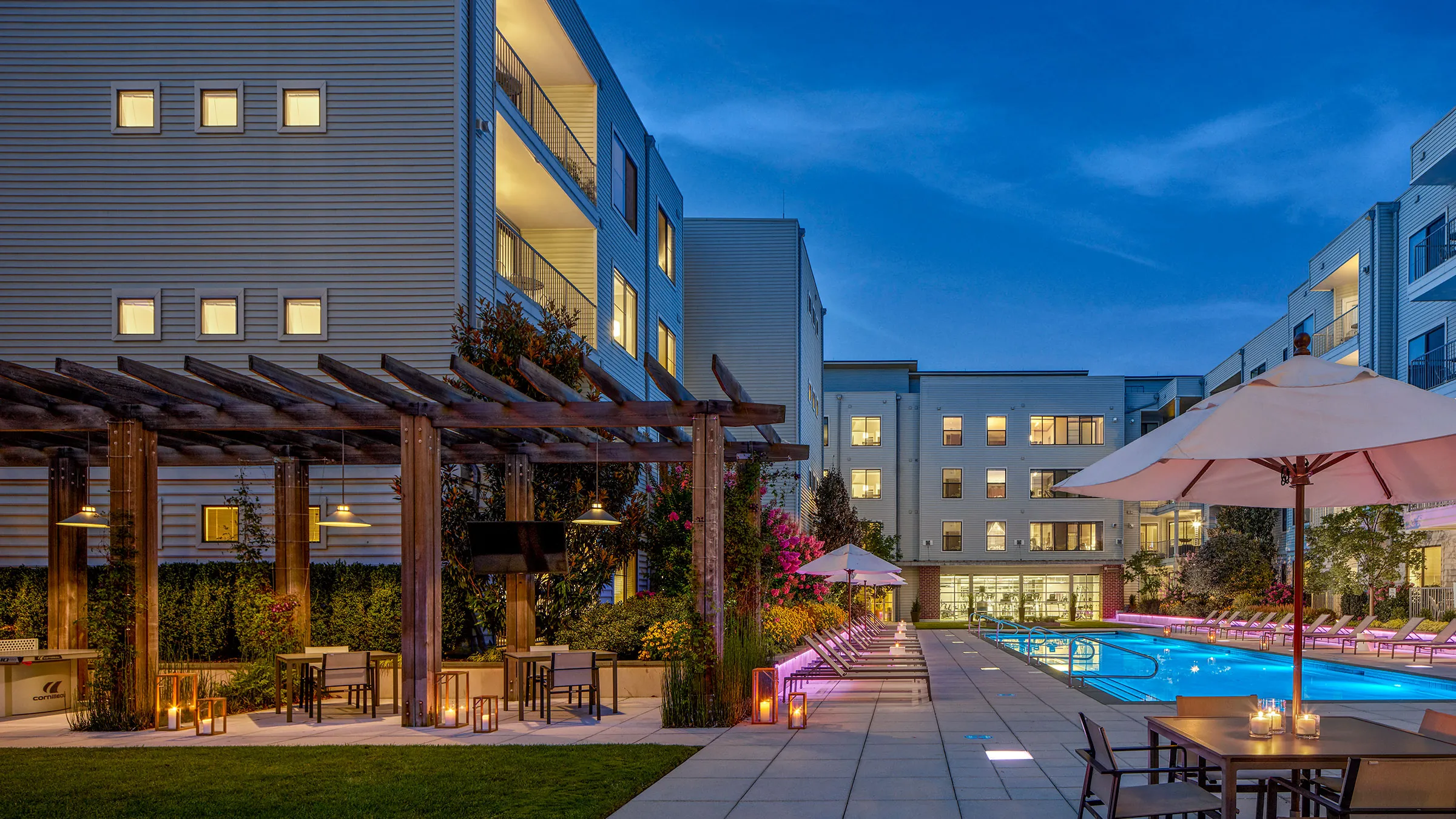 a pool and patio area with chairs and umbrellas