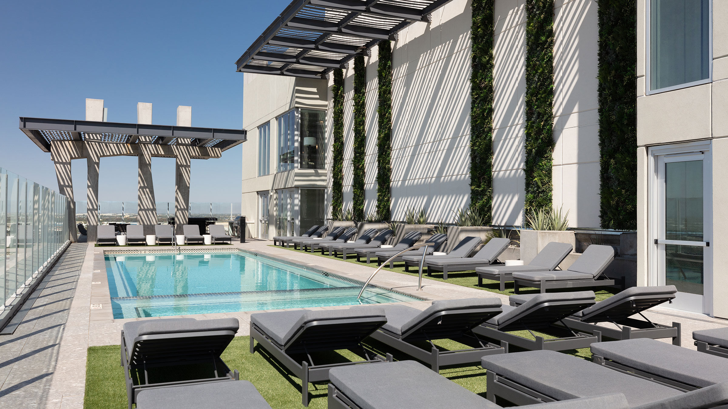 a pool with lounge chairs and a building