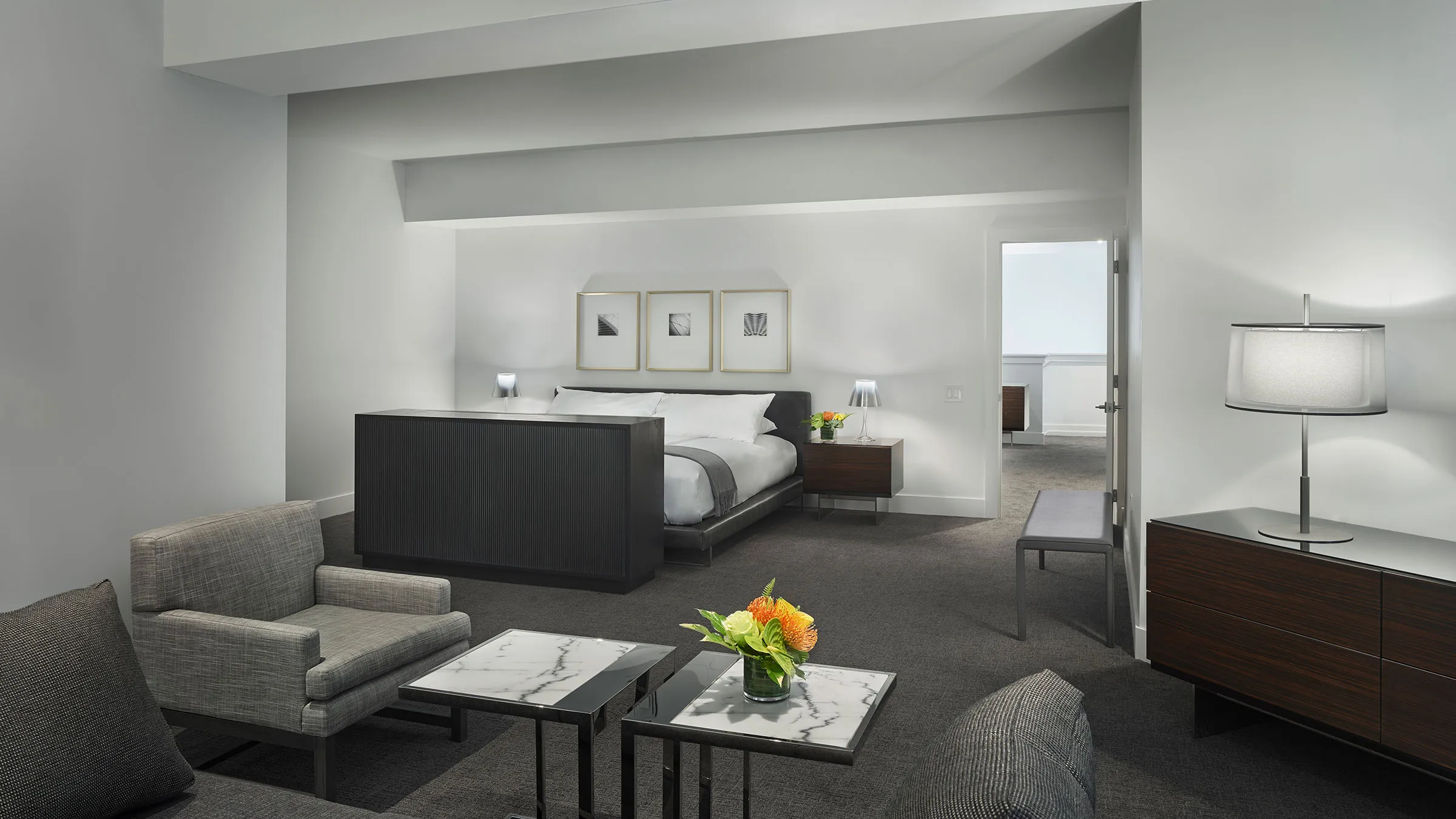 a room with a bed and chairs