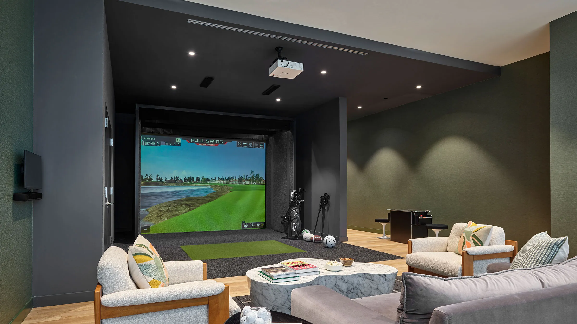 a room with a large screen and a golf course