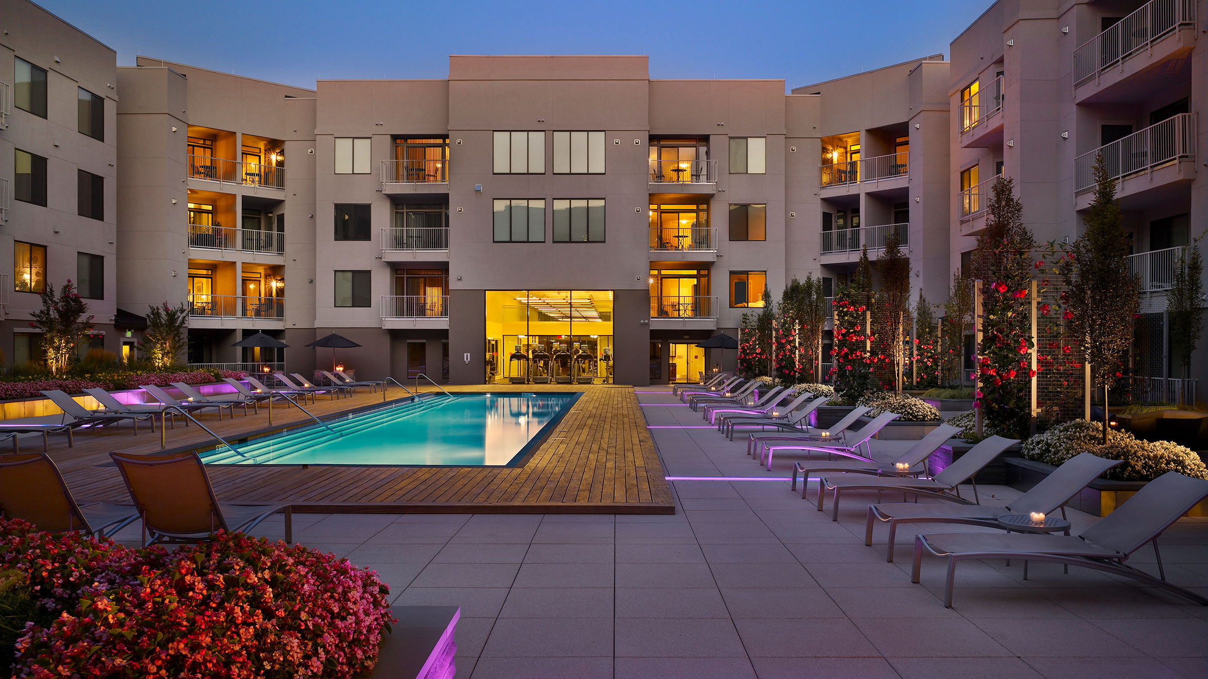 a pool and lounge chairs in front of a building