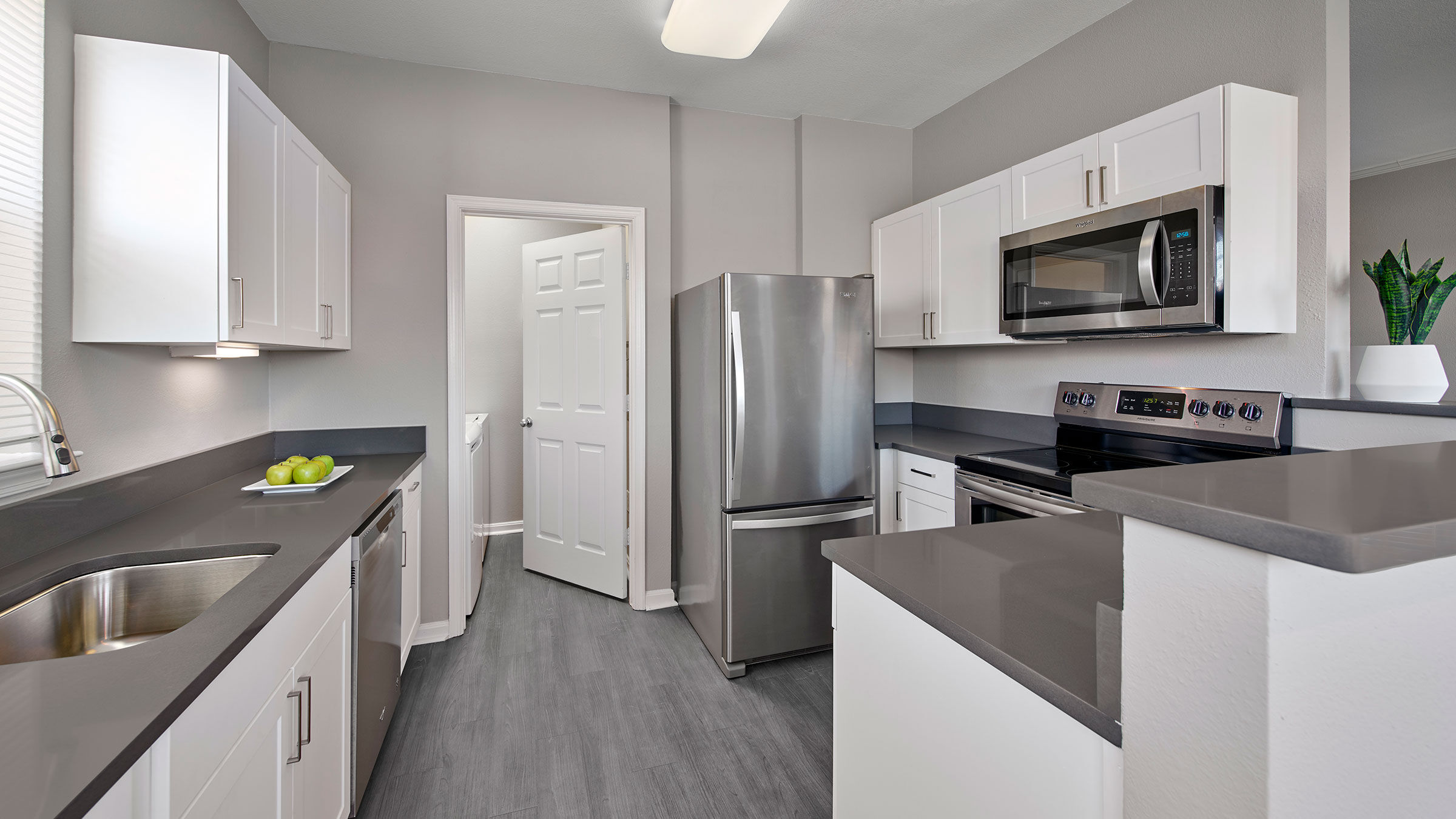 a kitchen with white cabinets and stainless steel appliances