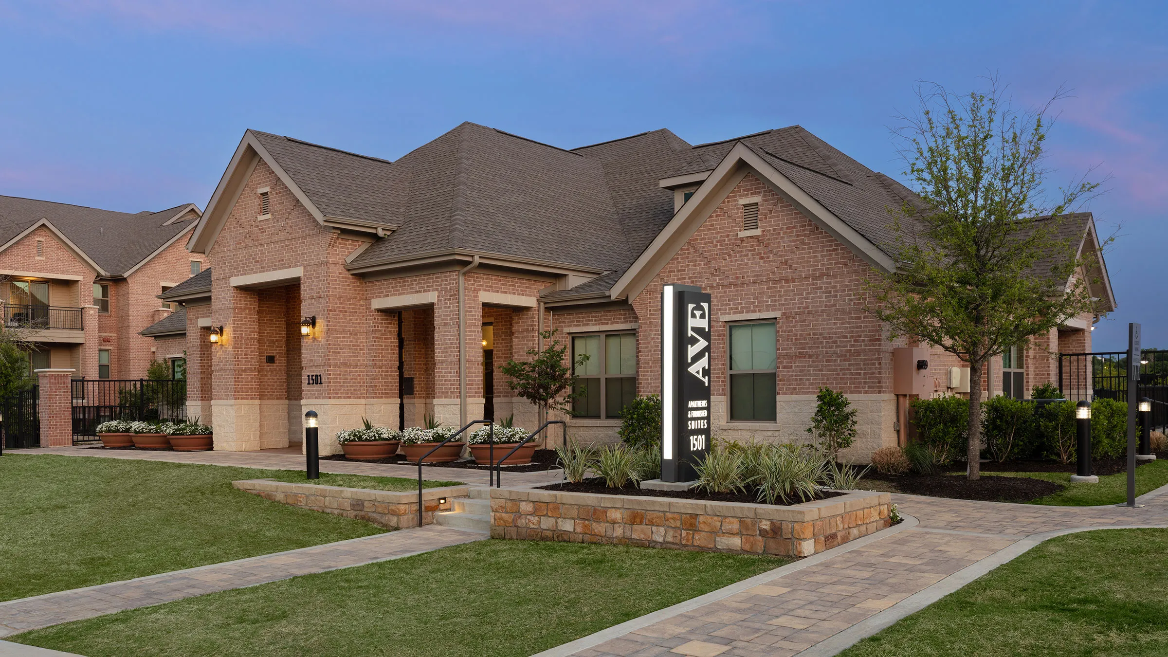 a brick house with a sign in front of it