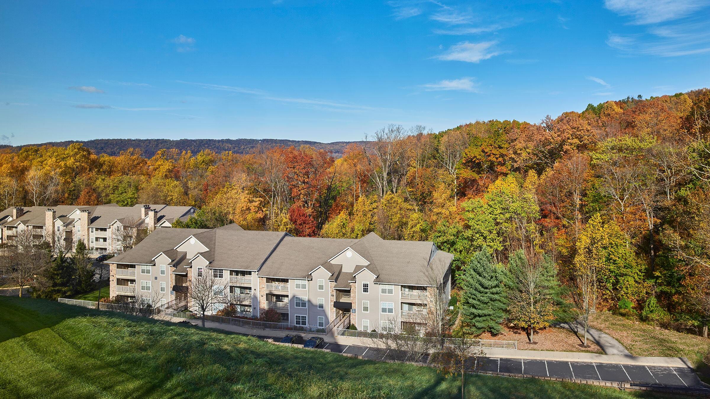 a group of apartment buildings with trees in the background