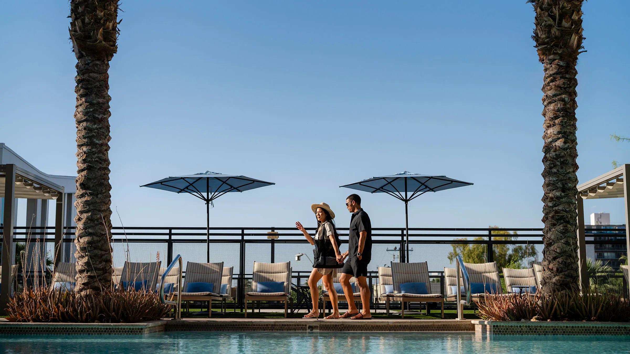 a man and woman walking by a pool