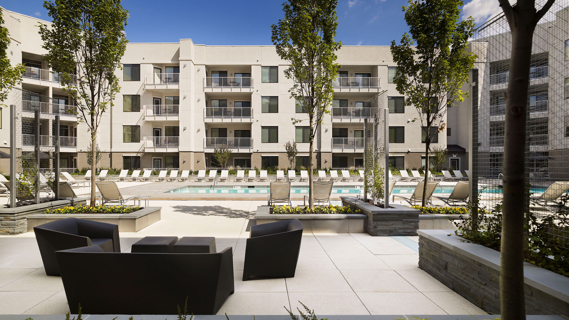 a pool and chairs in front of a building