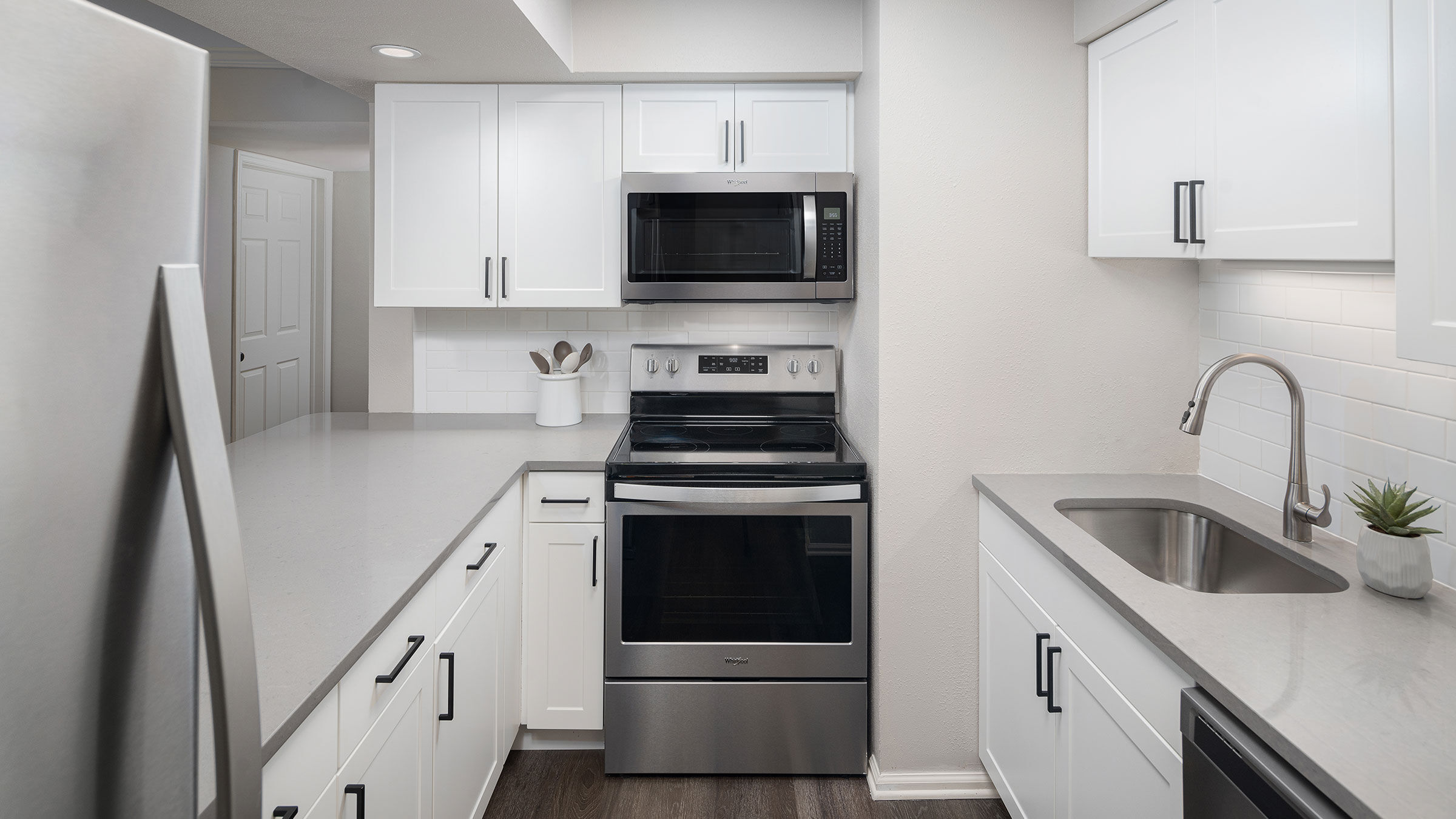 a kitchen with white cabinets and stainless steel stove