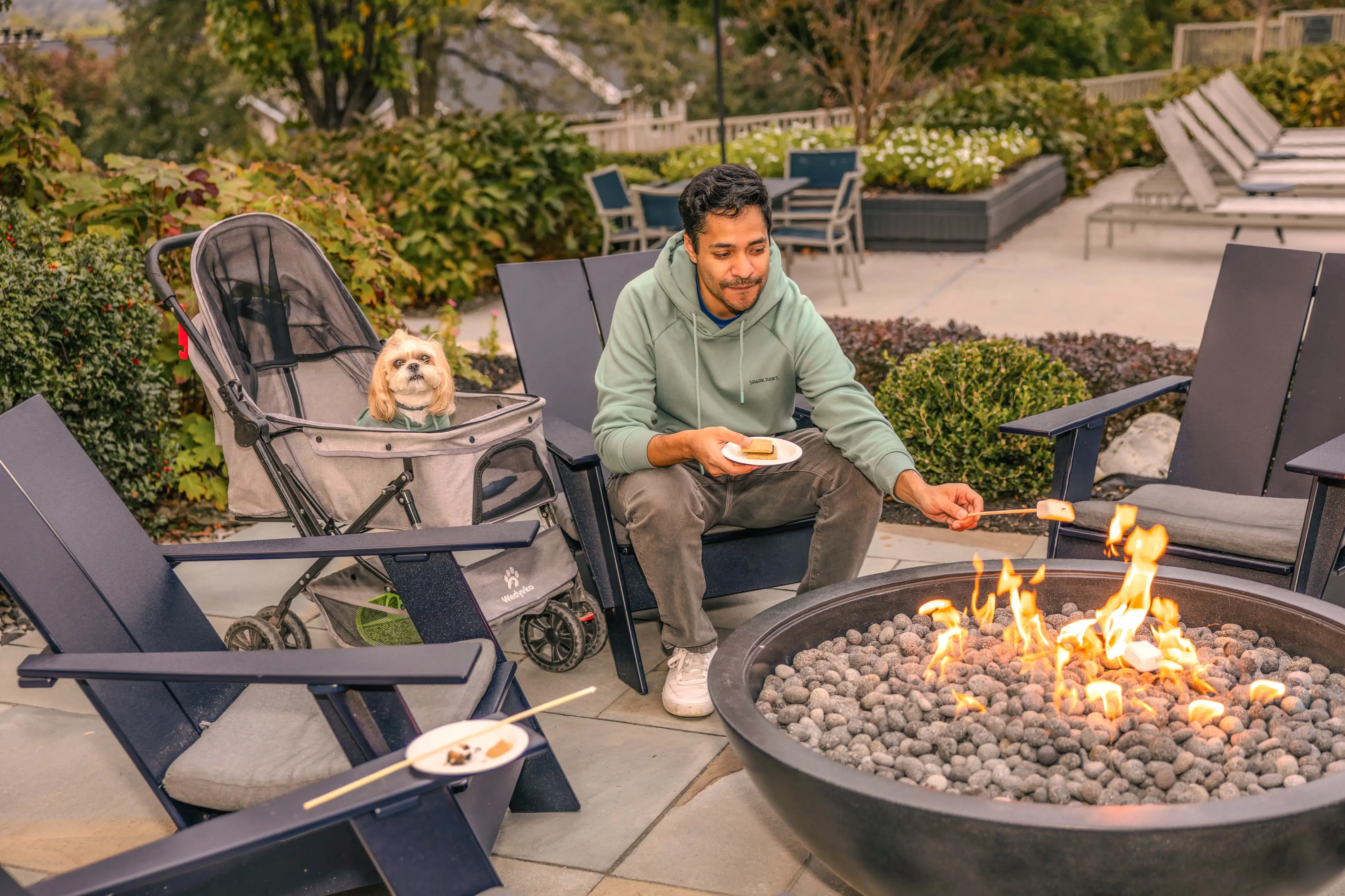 a man sitting on a patio with a dog on his lap