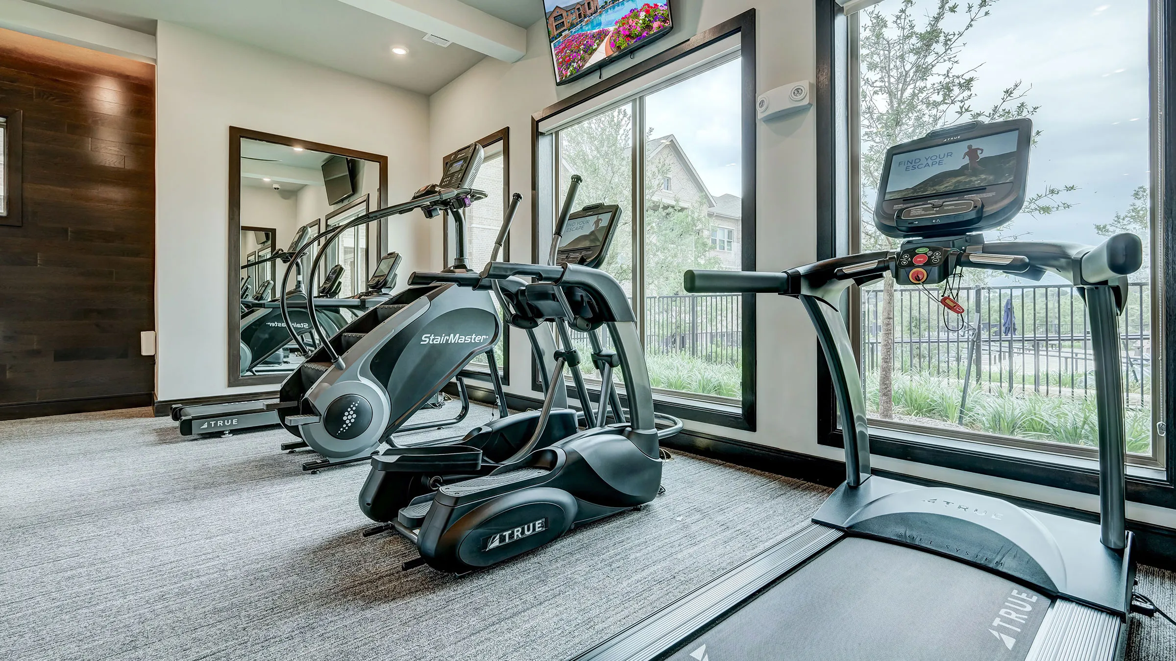 a room with exercise machines and windows