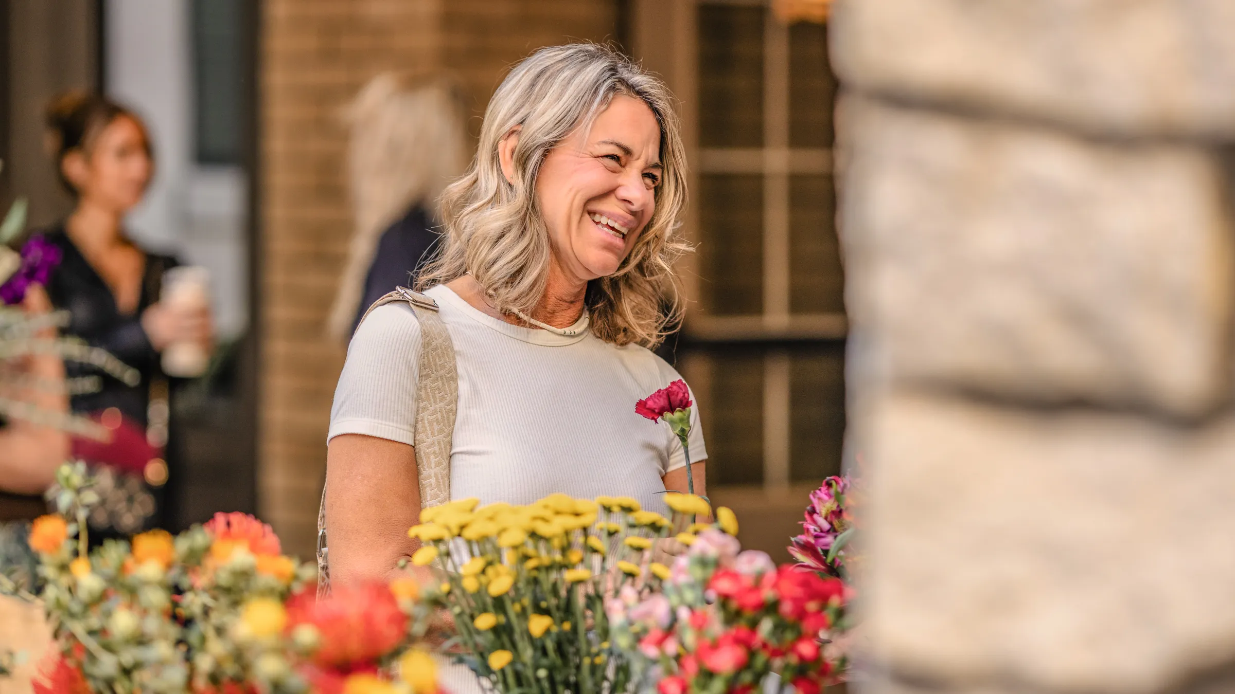a woman smiling at flowers