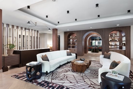 Lounge area with cream couches and green club chairs. Bar like area with high top seating, large win