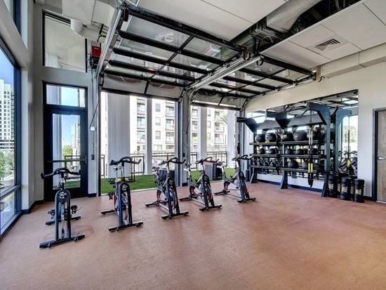 Fitness Center with green and gray flooring, fitness machines and steels beams