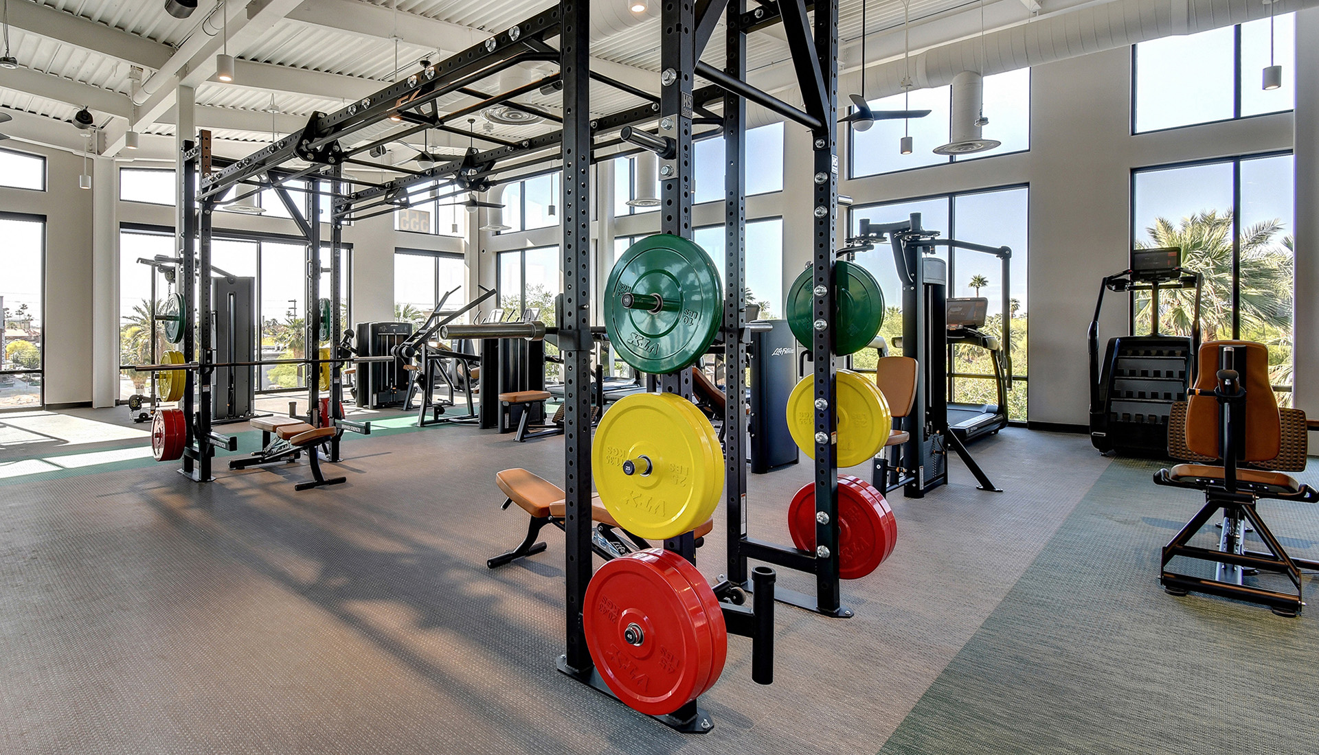 Fitness Center with green and gray flooring, fitness machines and steels beams