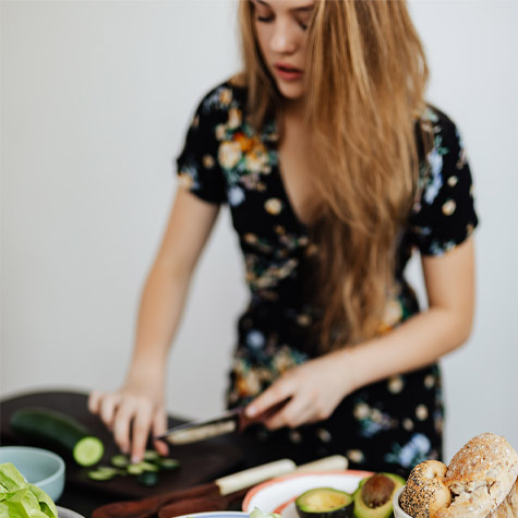Woman chopping veggies on white background