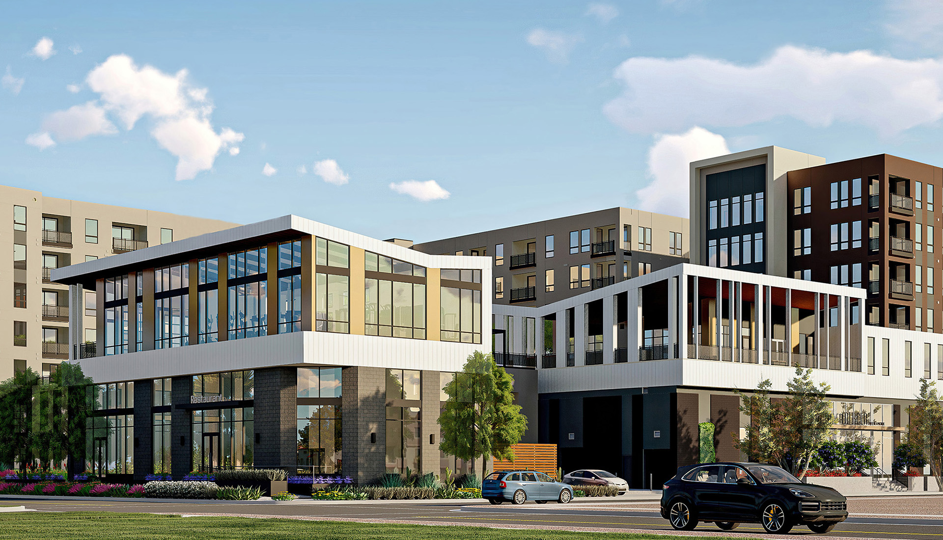 Exterior of building with large windows, cars driving by and greenery